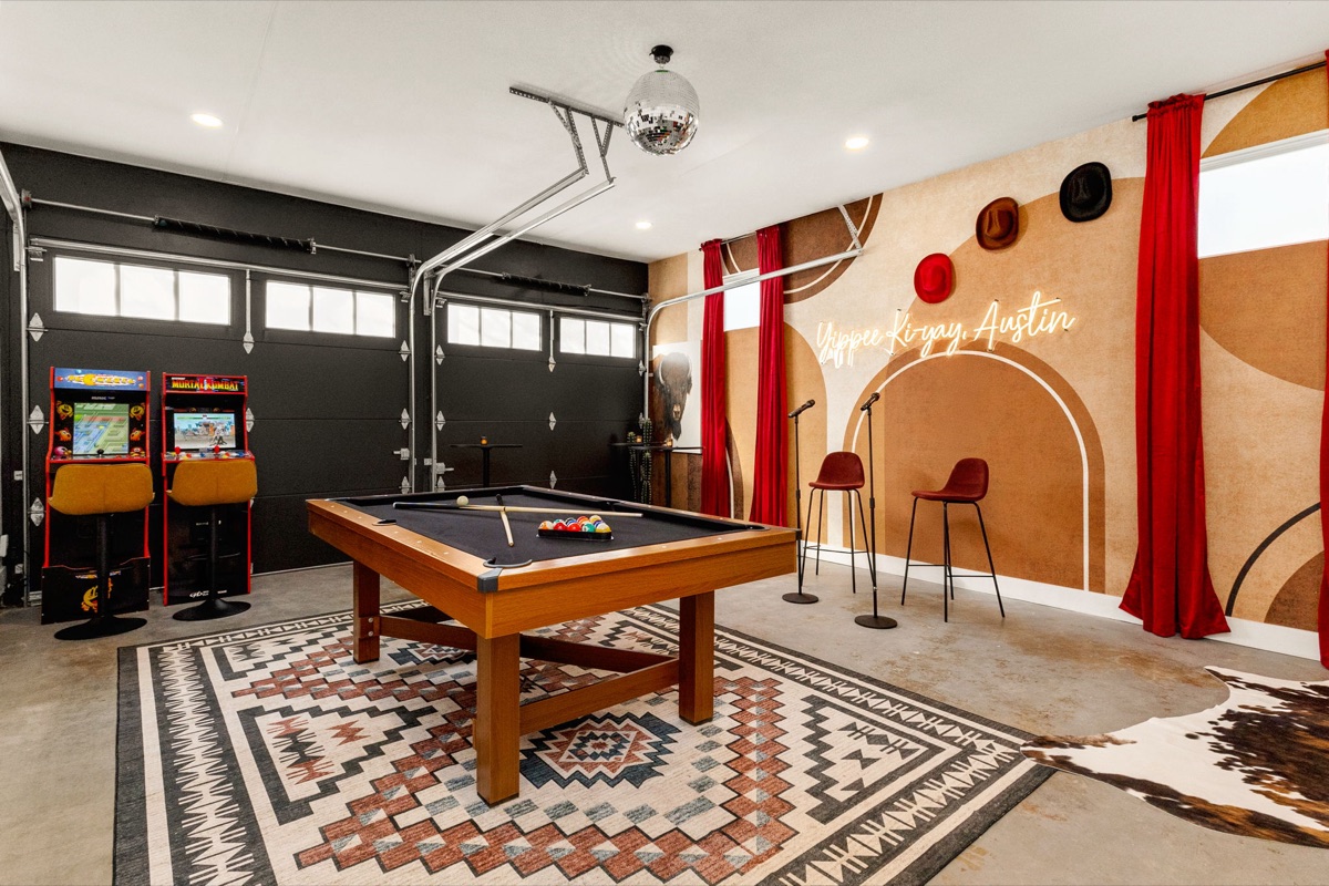 SoCo Cowgirl game room with pool table, arcade cabinets, and karaoke stage