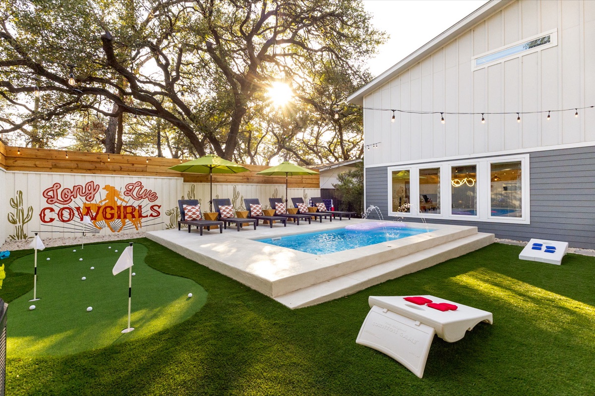 SoCo Cowgirl backyard with pool, putting green, and Long Live Cowgirls mural